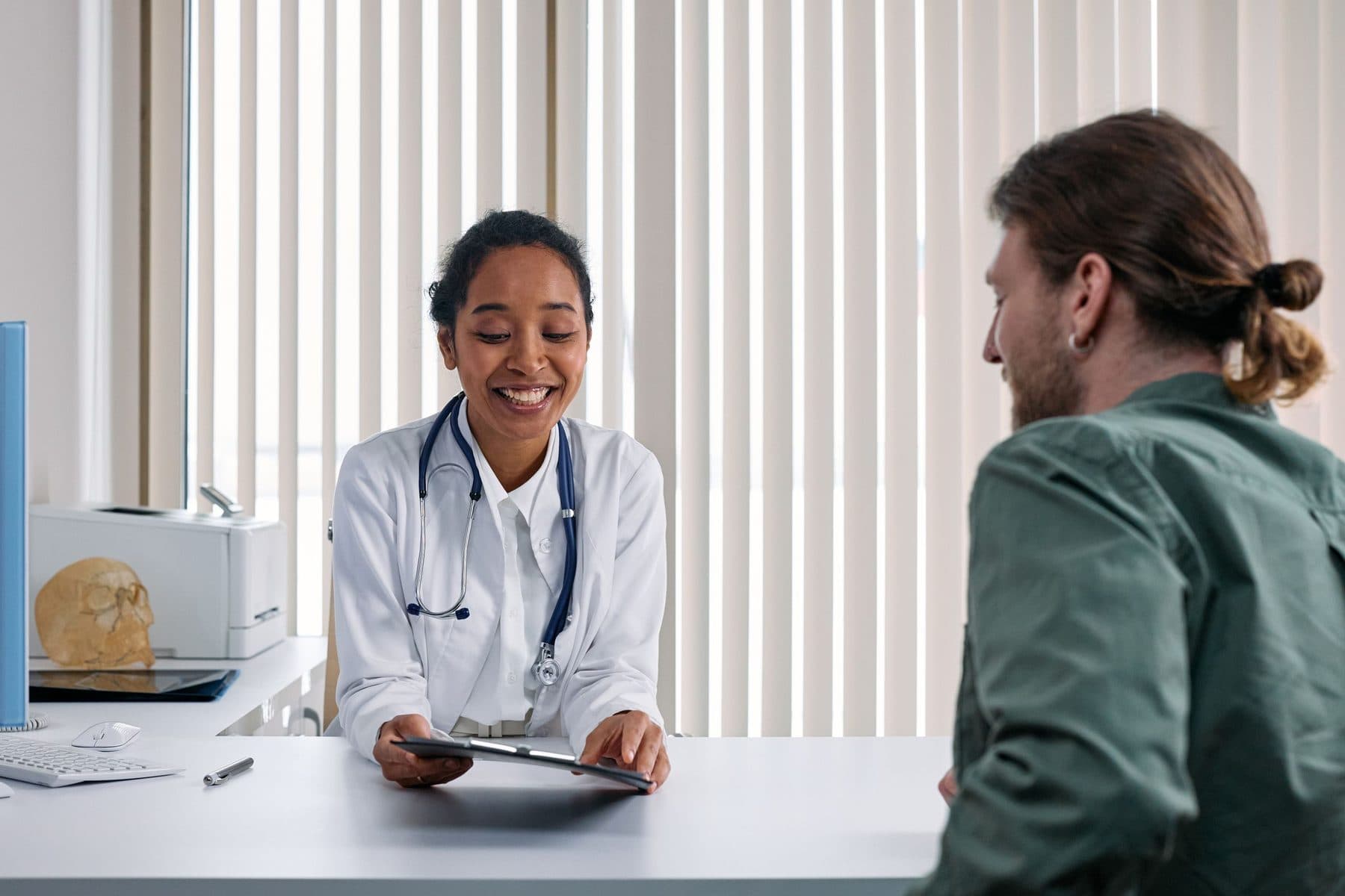 Profissional de saúde em consulta acolhedora com um paciente